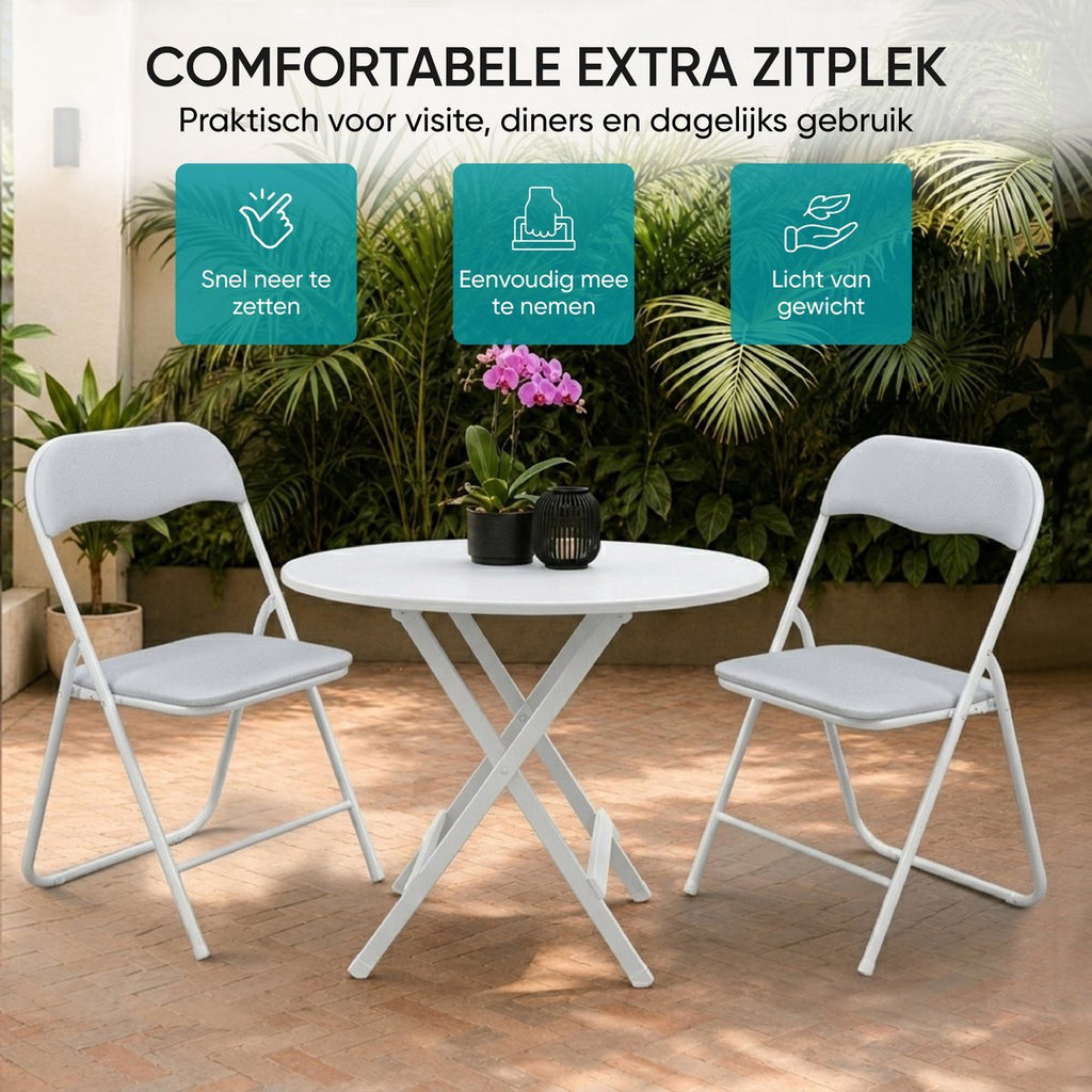 Twee witte klapstoelen met ronde tafel op een terras