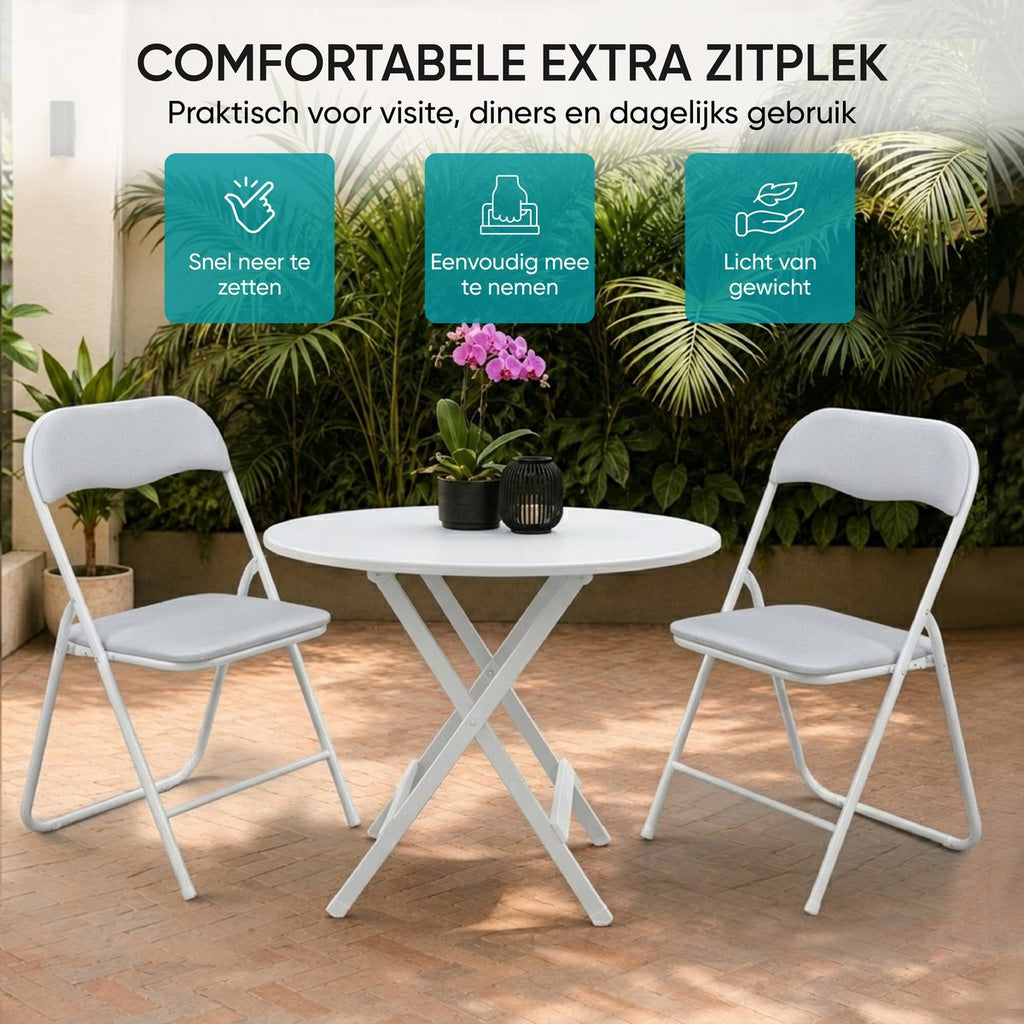 Twee witte klapstoelen met ronde tafel op een terras