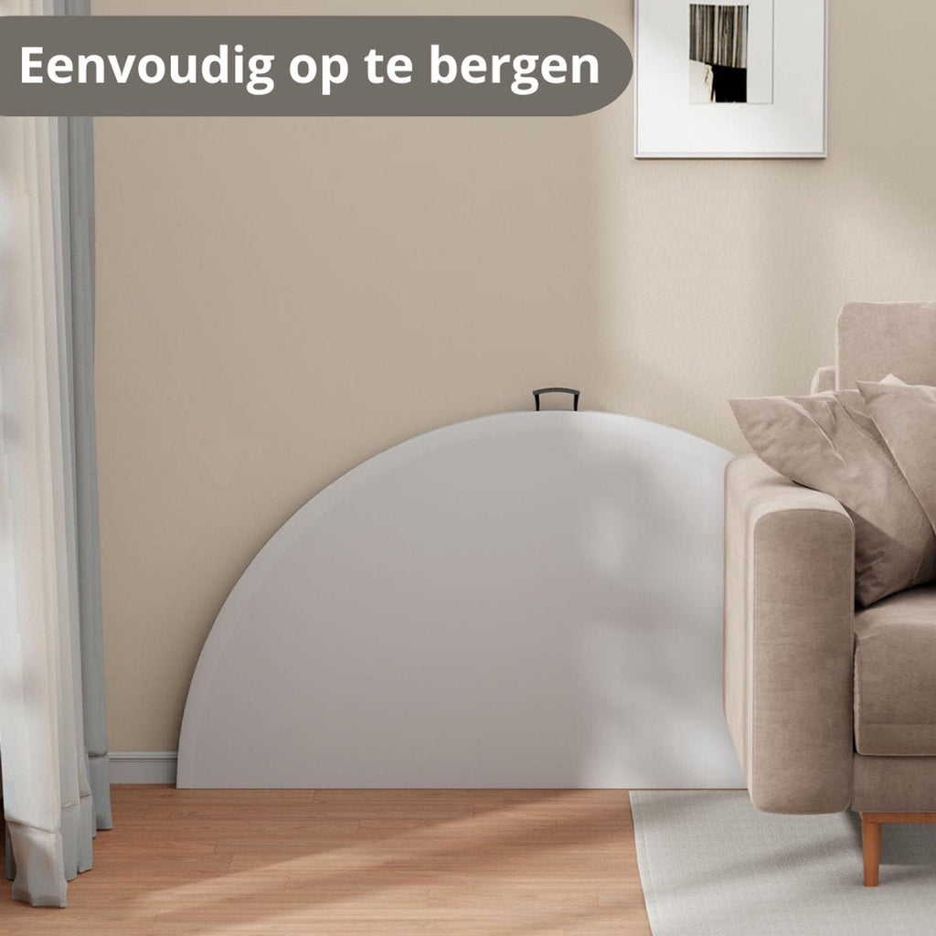 Ingeklapte witte ronde tafel tegen de muur opgeborgen