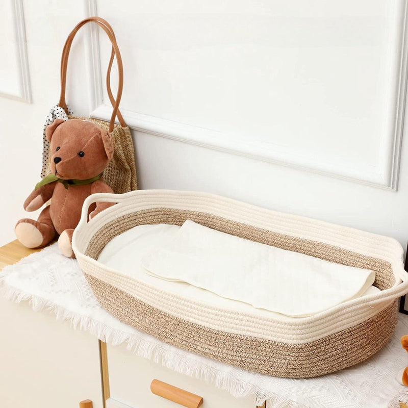 Beige gevlochten verschoonmand met matrasje op een commode