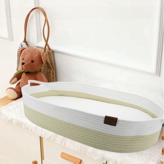 Crème gevlochten verschoonmand met matrasje op een commode