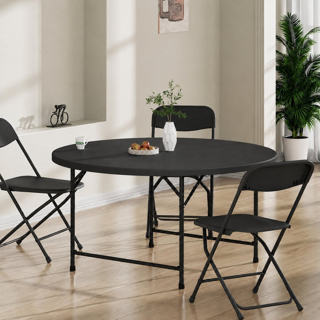 Zwarte ronde tafel met klapstoelen in een eetkamer